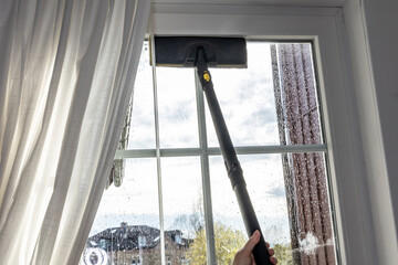 Washing the glass surface of the window with a steam generator brush