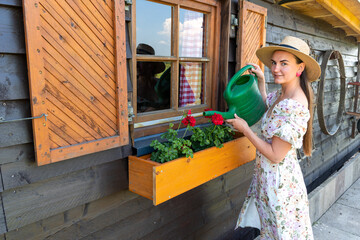 A woman waters flowers from a watering can
