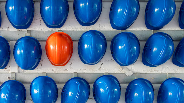 Un casque orange parmi des casques bleus