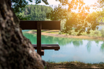 Bench by the lake, serene seating spot overlooking the water, tranquil outdoor scene for relaxation concept