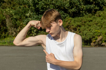 Teenage boy flexing his arm muscles