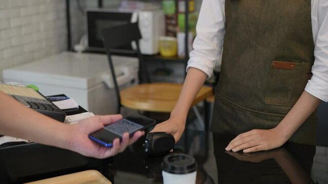 Coffee shop concept of 4k Resolution. Employees are serving drinks and charging customers by scanning their mobile phones.