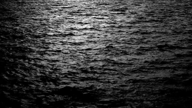 Sea water ripple waves in the moonlight. Bright glow on the sea waves. Night life, calm view scene, dark, dusk, evening, magic, water, nature, slow motion, static scene, mid shot, hd. ProRes 422 HQ.