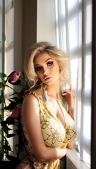 Fototapeta premium Bimbo girl with heavy makeup posing as a female model with a sexy look and beautiful hair