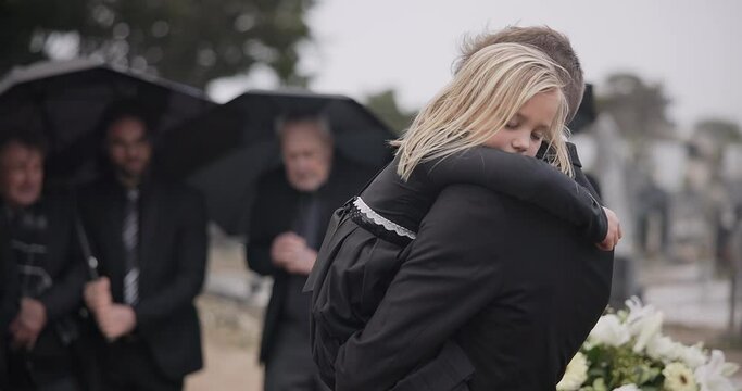 Sad, hug and a father and child at a funeral with depression and mourning at the graveyard. Holding, young and a dad with care and love for a girl kid at a cemetery burial and grieving together