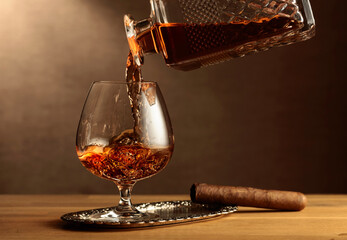 Cognac and cigar on an oak table.
