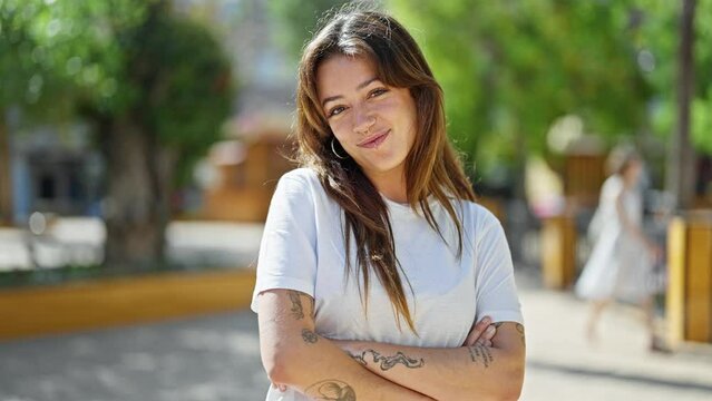 Young beautiful hispanic woman smiling confident standing with arms crossed gesture at park