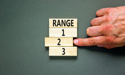 Time to range 2 symbol. Concept word Range 1 2 3 on wooden block. Businessman hand. Beautiful grey table grey background. Business planning and time to range 2 concept. Copy space.
