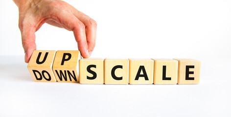 Upscale or downscale symbol. Concept words Upscale or Downscale on wooden cubes. Beautiful white table white background. Businessman hand. Business upscale or downscale concept. Copy space.