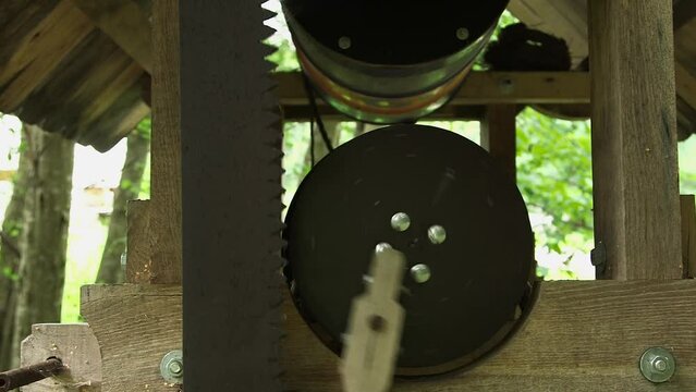 dolly close up shot of decorative useless mechanical wooden-metal saw moving mechanism