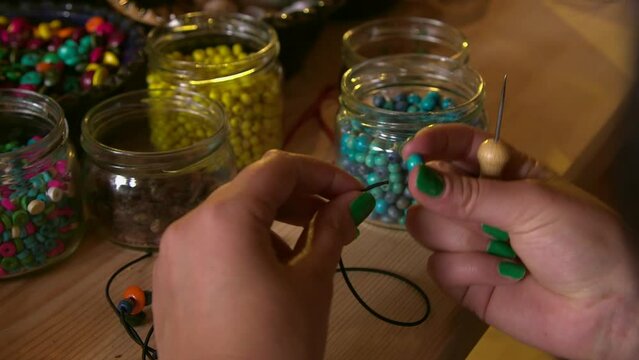 dolly close up shot of bead workshop with a lot of different wooden and plastic beads as well as shells