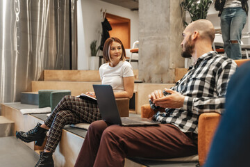 Lovely girl listening to her hairless male colleague sharing a beautiful story. Hairless male explaining how he is feeling to his gorgeous female colleague