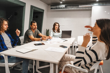 Middle-aged company manager joking with his brunette female colleague