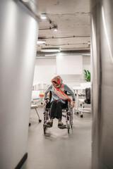 Fototapeta na wymiar Disabled woman rolling wheelchair through the office