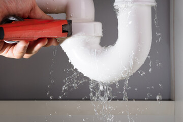 Plumber Fixing Sink Pipe With Adjustable Wrench