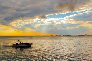 Obraz premium The amazing dramatic sunset sky with clouds over the Sea of Marmara surface in the evening in Turkey. Speed boats, motor boats are sailing. Cloudscape, nature and summer concept