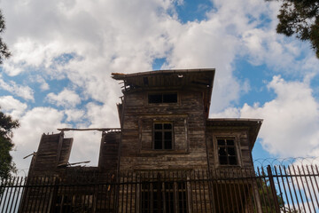 White clouds over the old ramshackle historic wooden building on the Princes Islands near the city of Istanbul - afternoon, daylight. Architecture concept
