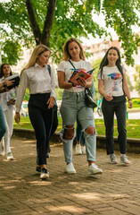 Classmates walking with their notebooks