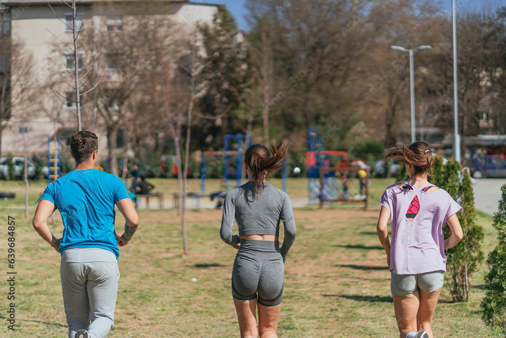 Wall mural Sports friends running in the park