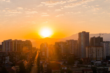 View of the breathtaking sunrise sky with the rising sun over the city of Batumi, Georgia. City is slowly awakening. Urban, early morning, summer and cityscape concept