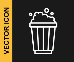 White line Popcorn in cardboard box icon isolated on black background. Popcorn bucket box. Vector