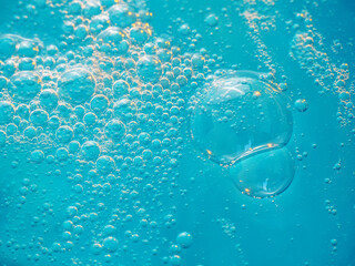Texture of soap bubbles in close up. Bubble bath. Gel for washing or washing hands.Blue background...