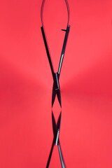 Manicure scissors for nails and brows, beauty tools for eyelash extension beauty salon procedure. Professional accessories and products for lash application on red background