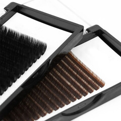 Mockup palette of black and brown eyelash extensions for making fans and their application. A tray of Russian volume lashes in the frame on white background. Set of beauty tools can be added