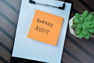 Concept of Energy Audit write on sticky notes isolated on Wooden Table.
