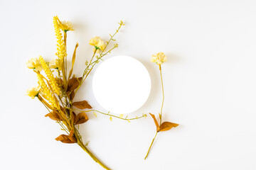 Round white card with a bouquet of yellow flowers on a white background. , top view and flat lay,...