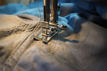 the process of repairing clothes with a sewing machine, a needle on an electric sewing machine....