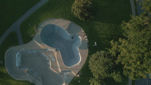 Top-view drone shot of a skateboarder in a skate park skating pool for skaters 