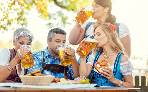 Waitress getting lots of beer to patrons of Bavarian pub