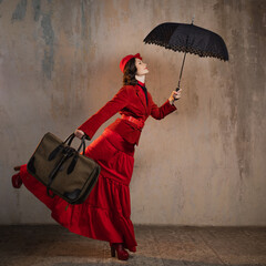 A stylish lady in a red old-fashioned suit with a hat and a lace umbrella - 639693478