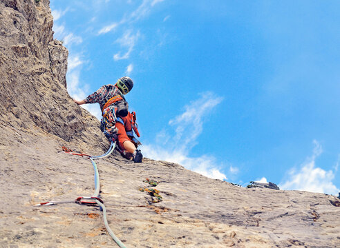Young woman climbing in the Dolomits, Italy. The rock-climber during rock conquest