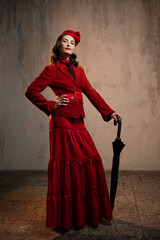 Mary Poppins. A stylish lady in a red old-fashioned suit with a hat and a lace umbrella