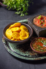 Sopaipilla. Latin American food. Traditional chilean homemade pumpkin sopaipillas with typical salsas - chancho en piedra tomato sauce in stone mortar and spicy pebre