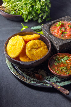 Sopaipilla. Latin American food. Traditional chilean homemade pumpkin sopaipillas with typical salsas - chancho en piedra tomato sauce in stone mortar and spicy pebre