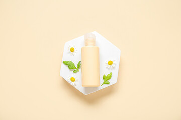 Composition with plaster podium, bottle of cosmetic product and chamomile flowers on color background