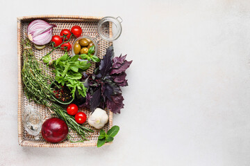 Tray with herbs, spices and vegetables on light background