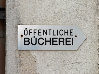 Öffentliche Bücherei (public library) sign with an arrow directing to the right. Building...
