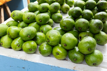 Green mango. Local fruits lay on a counter of a marketplace. Seychelles