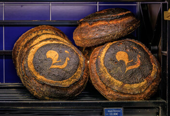Loaves of freshly baked rustic French levain sourdough bread tourte de meule at an artisanal bakery...