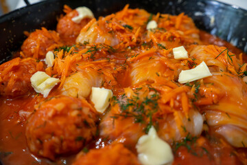 Traditional Ukrainian raw (unprepared) stuffed cabbage rolls with meat, rice and carrot in iron cauldron
