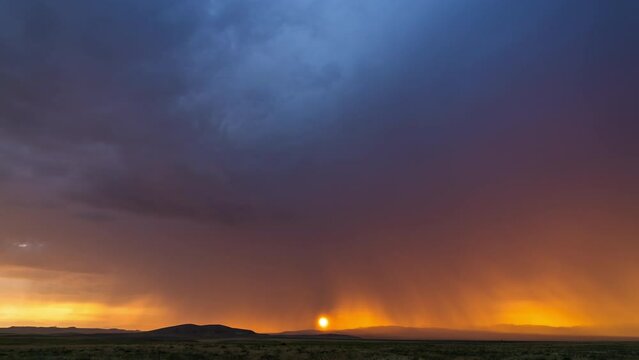 Colorful sunset timelapse as storm rolls the through sky and sun dips below the horizon in the Utah desert.