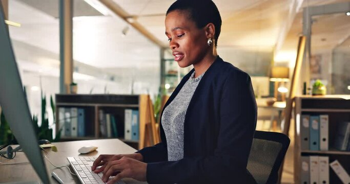 Business woman, computer and typing with document at a desk for data entry in night office. African entrepreneur person working at a desktop with paperwork for information, research or online report