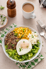 Breakfast bowl with quinoa, herbed corn, feta cheese and fried egg