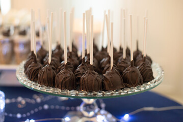 Amazing and delicious Chocolate covered dessert on sticks stacked on silver tray at dessert table