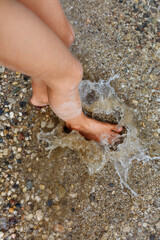 barefeet child legs jumping in the water with splashes