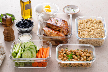 High protein healthy lunch meal prep in containers with chicken, quinoa, herbed chickpeas, vegetables and eggs